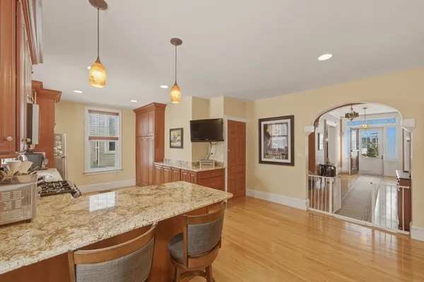 a kitchen with stainless steel appliances granite countertop a sink a stove and wooden floor