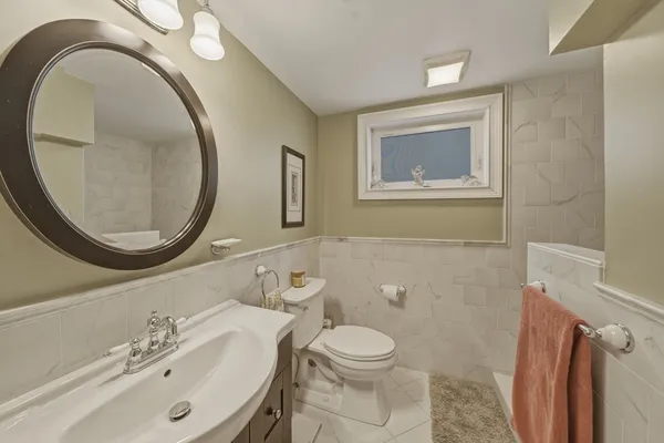 a bathroom with a toilet a sink and a mirror