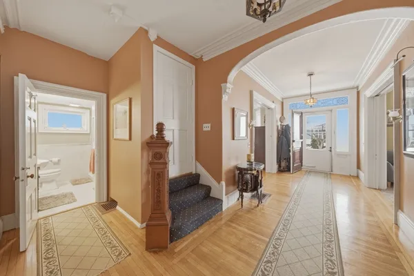 a view of a hallway with wooden floor and a living room