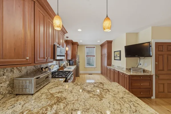 a kitchen with granite countertop a stove a sink and a microwave