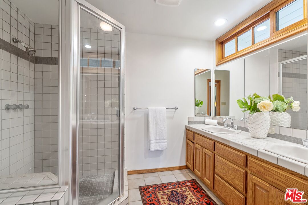 20650 Stagg Street Winnetka, CA 91306 - Photo 26 of 42 a bathroom with a granite countertop sink a toilet and shower