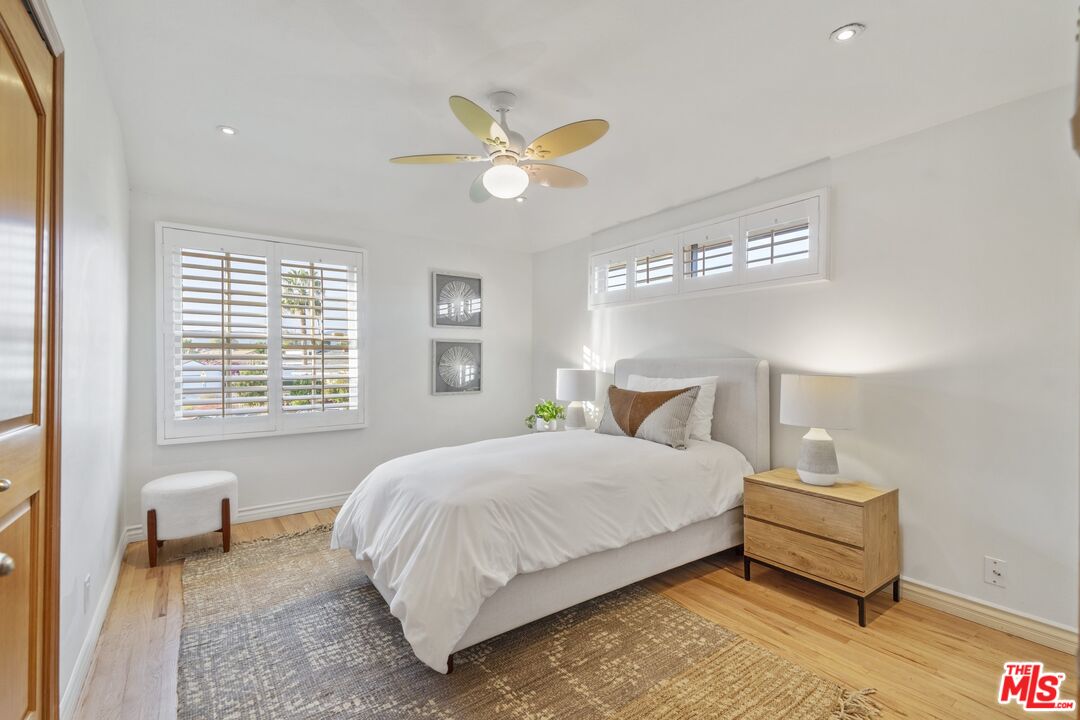 20650 Stagg Street Winnetka, CA 91306 - Photo 27 of 42 a bedroom with a bed and a chandelier