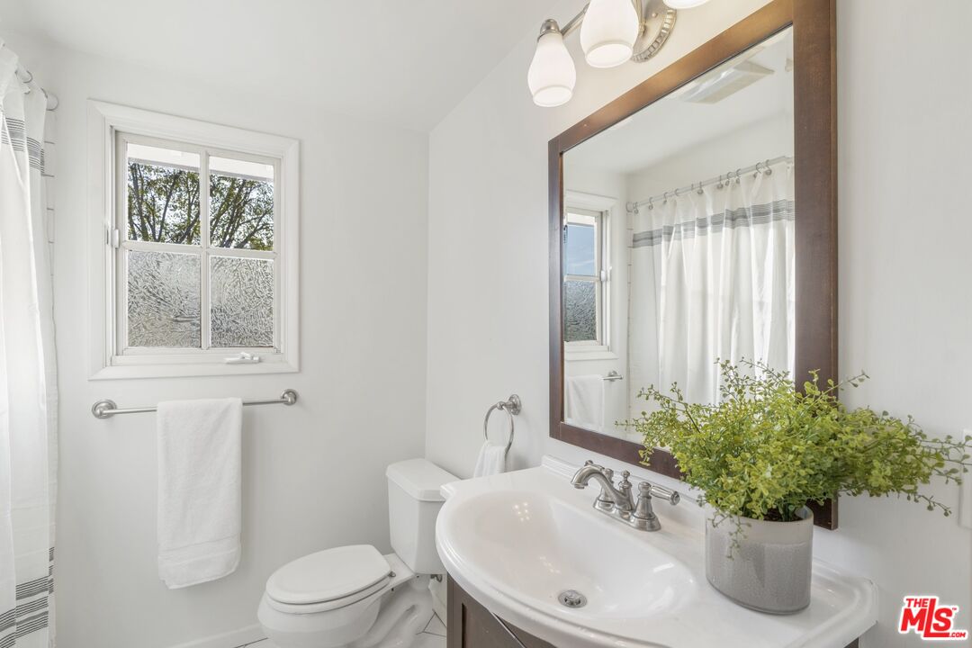 20650 Stagg Street Winnetka, CA 91306 - Photo 28 of 42 a bath room with a toilet a sink and a mirror