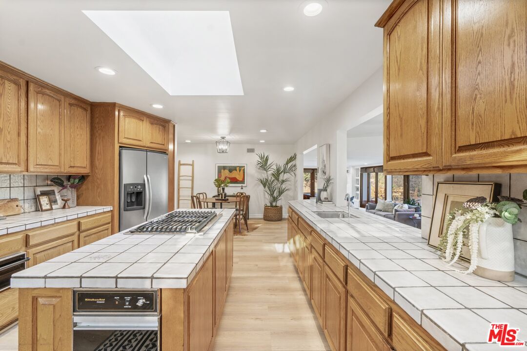 20650 Stagg Street Winnetka, CA 91306 - Photo 7 of 42 a large kitchen with kitchen island a large counter top space a sink stainless steel appliances and cabinets