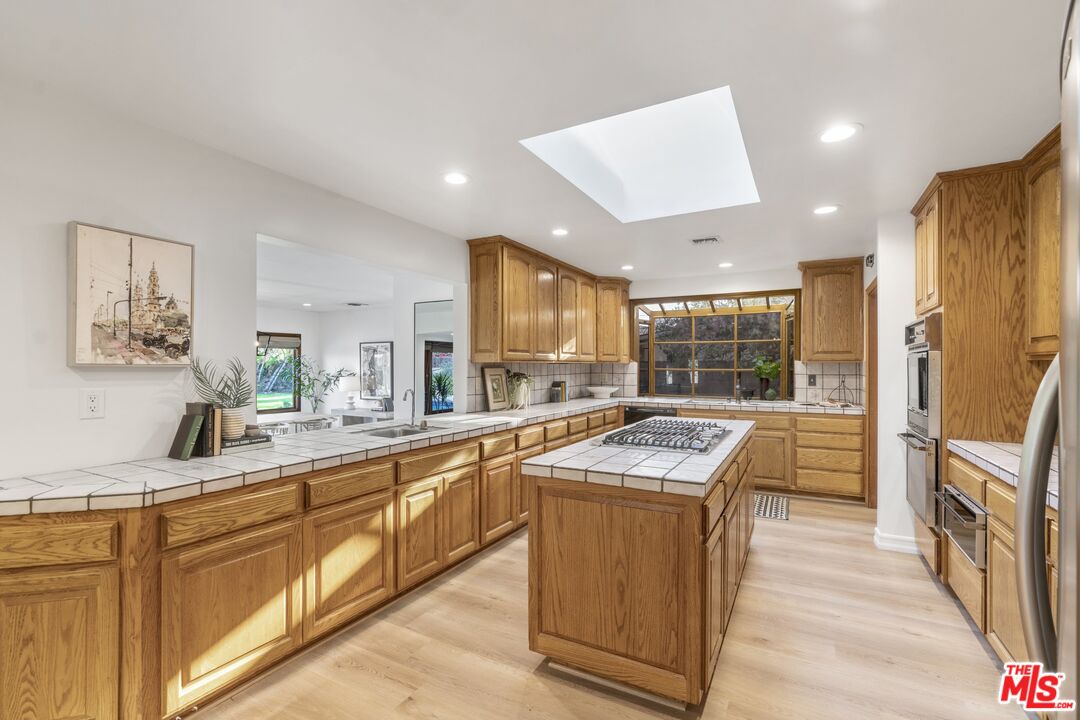 20650 Stagg Street Winnetka, CA 91306 - Photo 8 of 42 a kitchen with granite countertop a sink stove and refrigerator