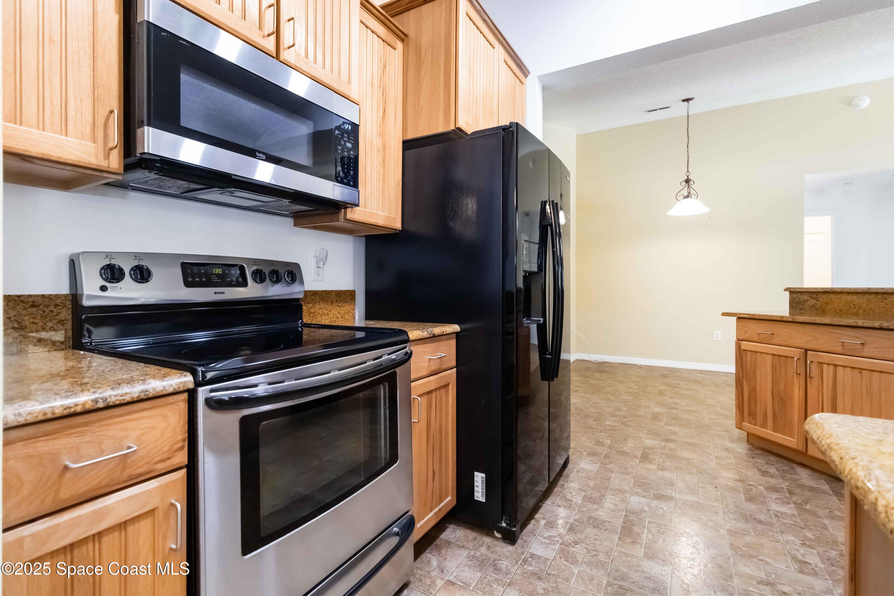 5230 Everett Street Cocoa, FL 32927 - Photo 7 of 29 a kitchen with stainless steel appliances granite countertop a stove microwave and refrigerator