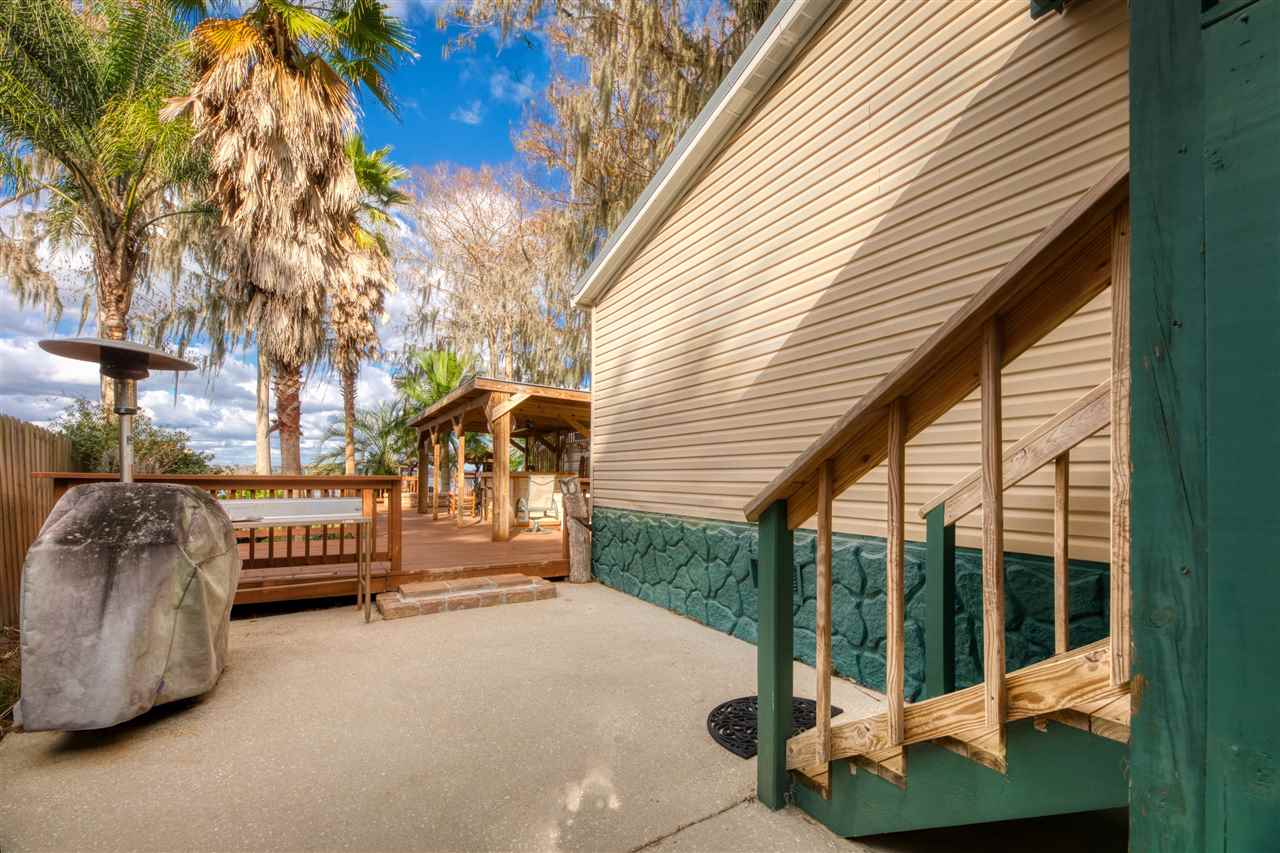 8580 G Palmo Fish Camp Road St. Augustine, FL 32092 - Photo 17 of 48 a view of a porch with a bench next to a yard