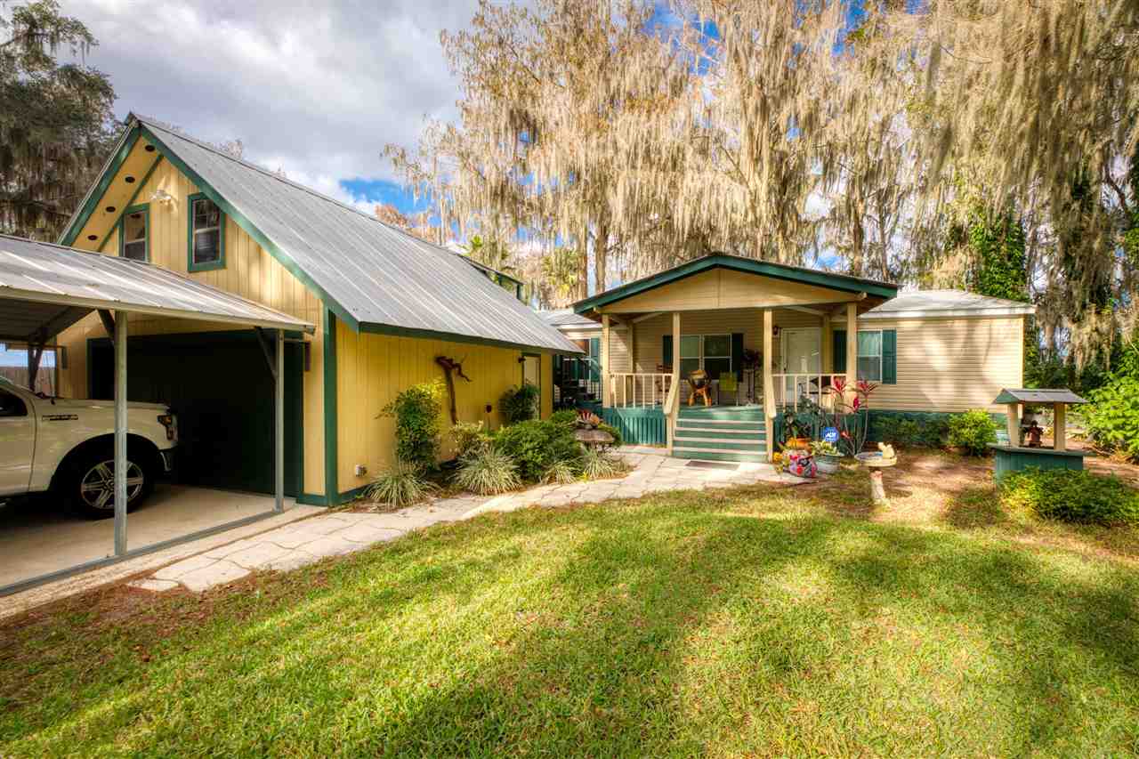 8580 G Palmo Fish Camp Road St. Augustine, FL 32092 - Photo 26 of 48 a front view of a house with a yard and garage