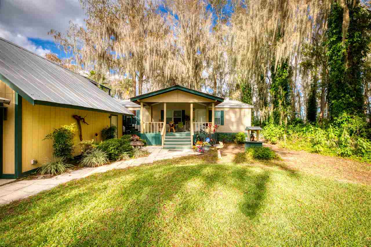 8580 G Palmo Fish Camp Road St. Augustine, FL 32092 - Photo 29 of 48 a front view of a house with swimming pool and porch with furniture