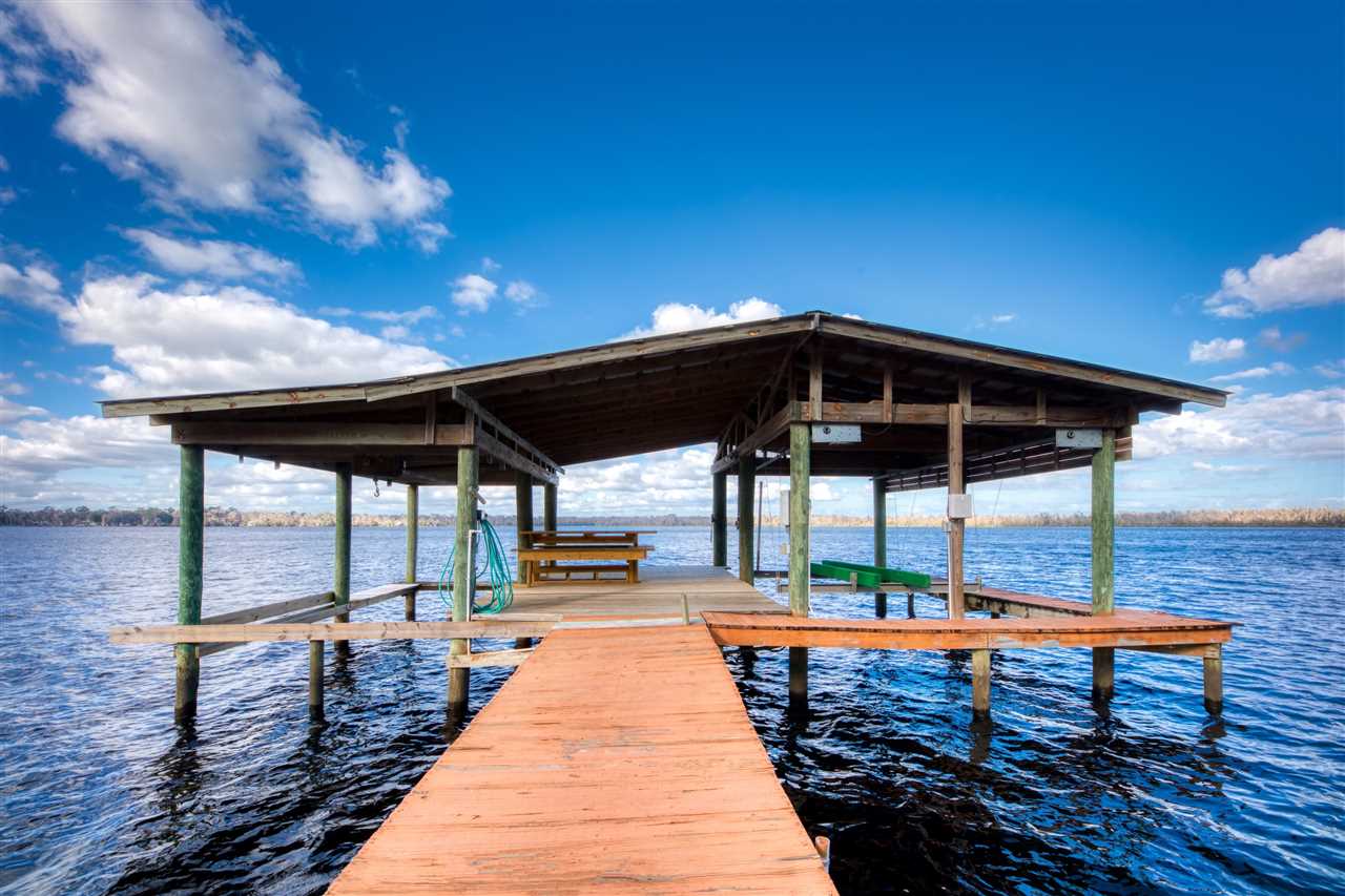 8580 G Palmo Fish Camp Road St. Augustine, FL 32092 - Photo 9 of 48 a view of a roof deck with dining table and chairs with wooden floor