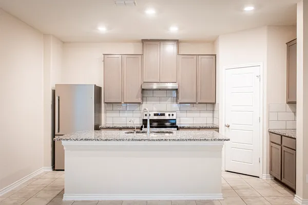 a kitchen with stainless steel appliances granite countertop a stove sink and cabinets