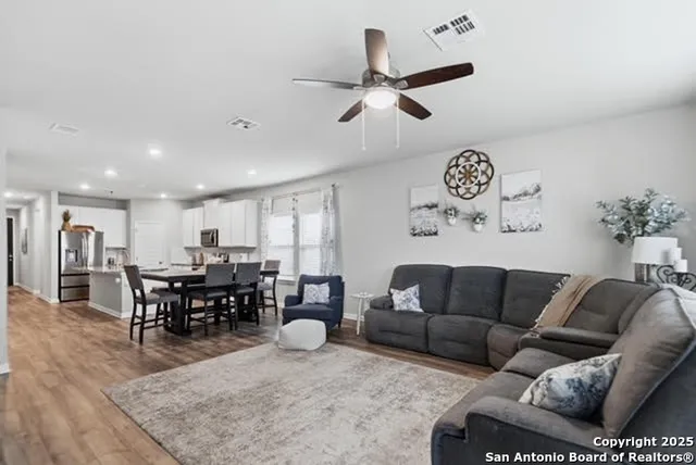 a living room with furniture kitchen view and a large window