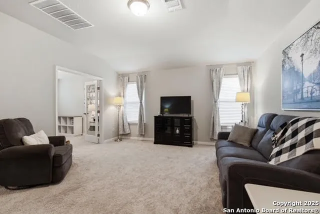a living room with furniture a flat screen tv and a window