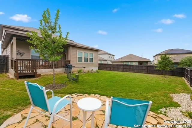 a view of an house with backyard and a patio
