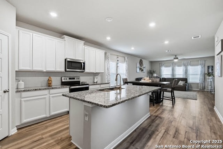 232 Colebrook Way Cibolo, TX 78108 - Photo 8 of 36 a kitchen with stainless steel appliances granite countertop wooden cabinets a sink a stove a dining table and chairs