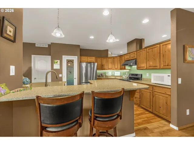 a kitchen with kitchen island a counter top space a sink appliances and cabinets