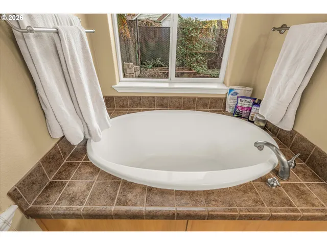 a bedroom with a bed table chair and a window