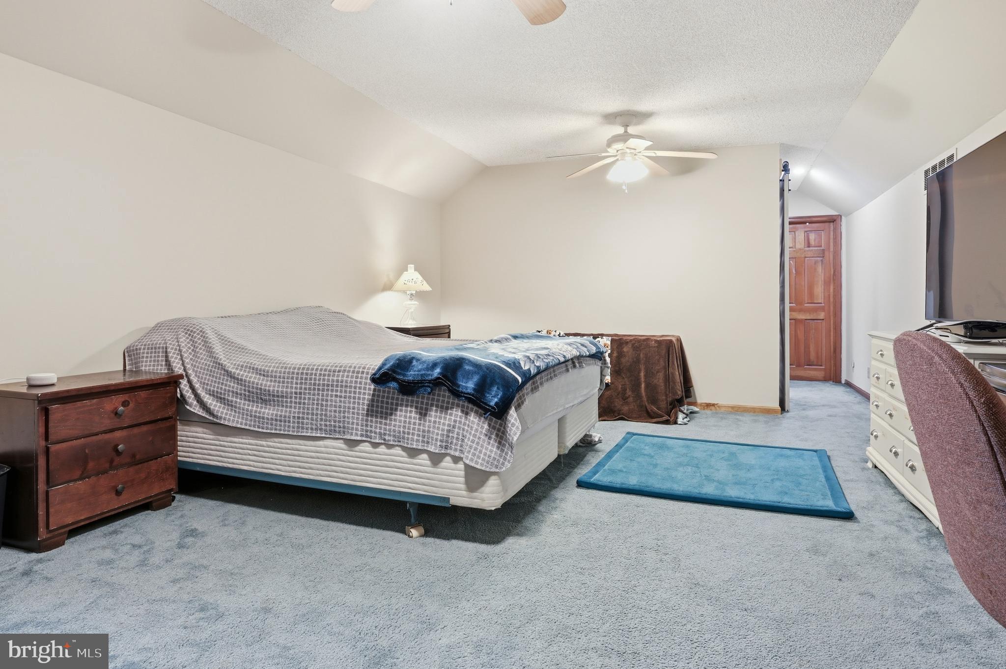 228 Firetower Road Camden Wyoming, DE 19934 - Photo 29 of 39 a spacious bedroom with a bed and a chandelier