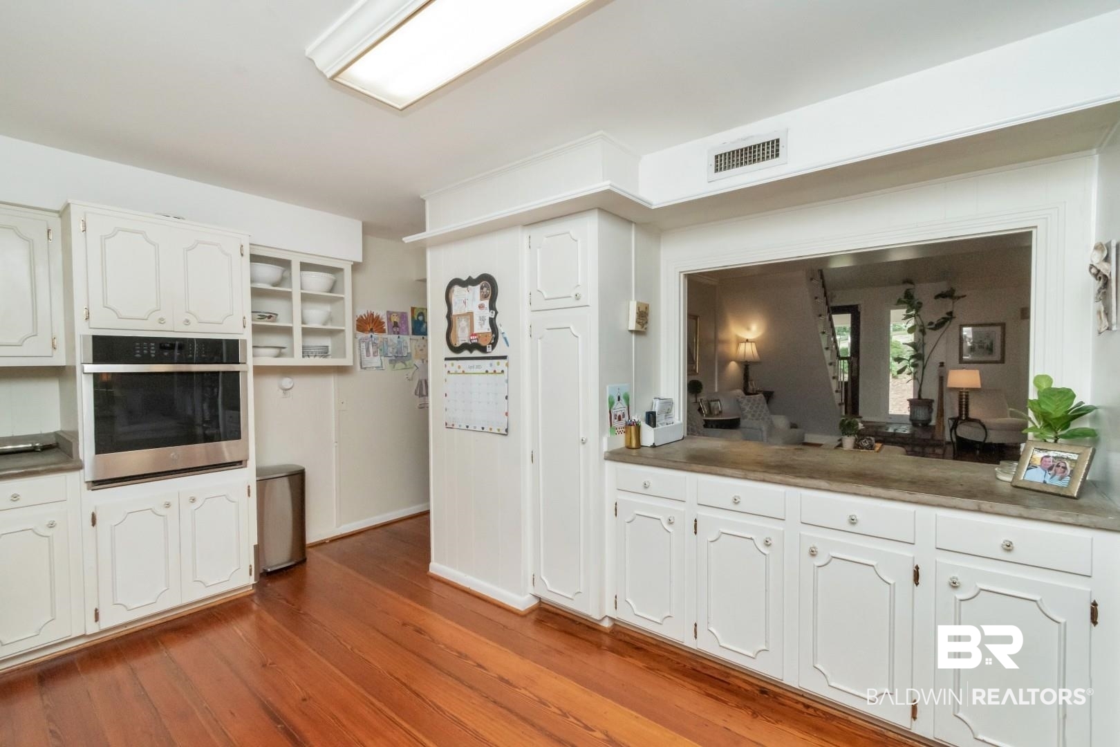117 Ridgelawn Drive West Mobile, AL 36608 - Photo 11 of 31 Kitchen featuring white cabinets, stainless steel oven, baseboards, visible vents, and wood finished floors
