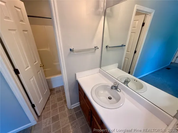a bathroom with a sink a toilet a mirror and shower