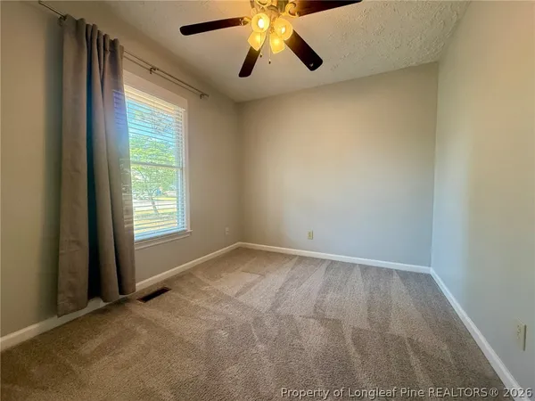 an empty room with closet and windows