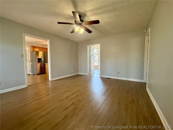 a view of an empty room with wooden floor