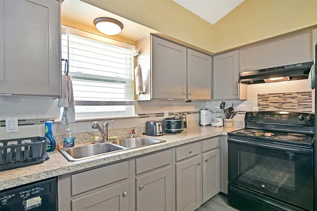 a kitchen with stainless steel appliances granite countertop a sink a stove and a microwave