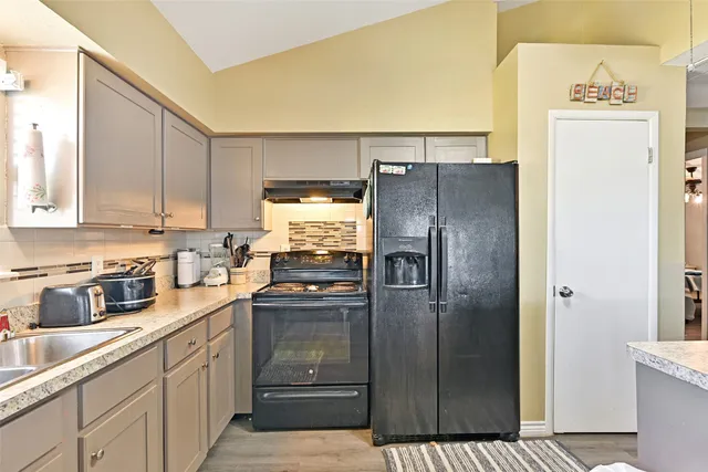 a kitchen with stainless steel appliances granite countertop a refrigerator and a stove