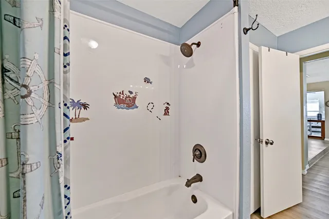 a bathroom with a bathtub a shower and a shower