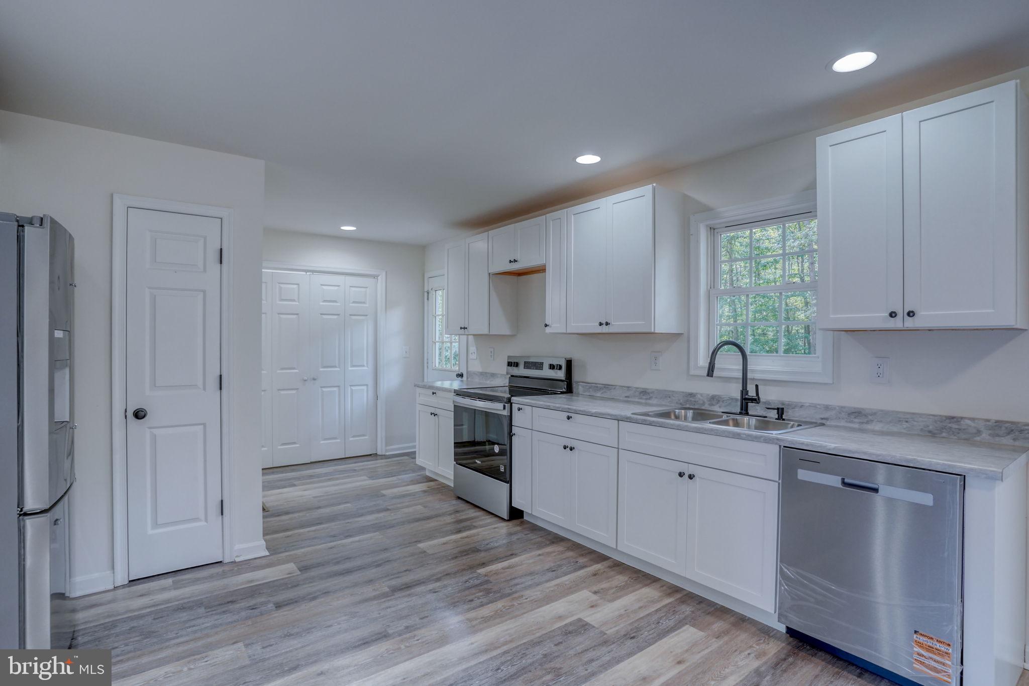 23678 Willow Pond Road Denton, MD 21629 - Photo 17 of 51 a kitchen with a sink cabinets stainless steel appliances and a window