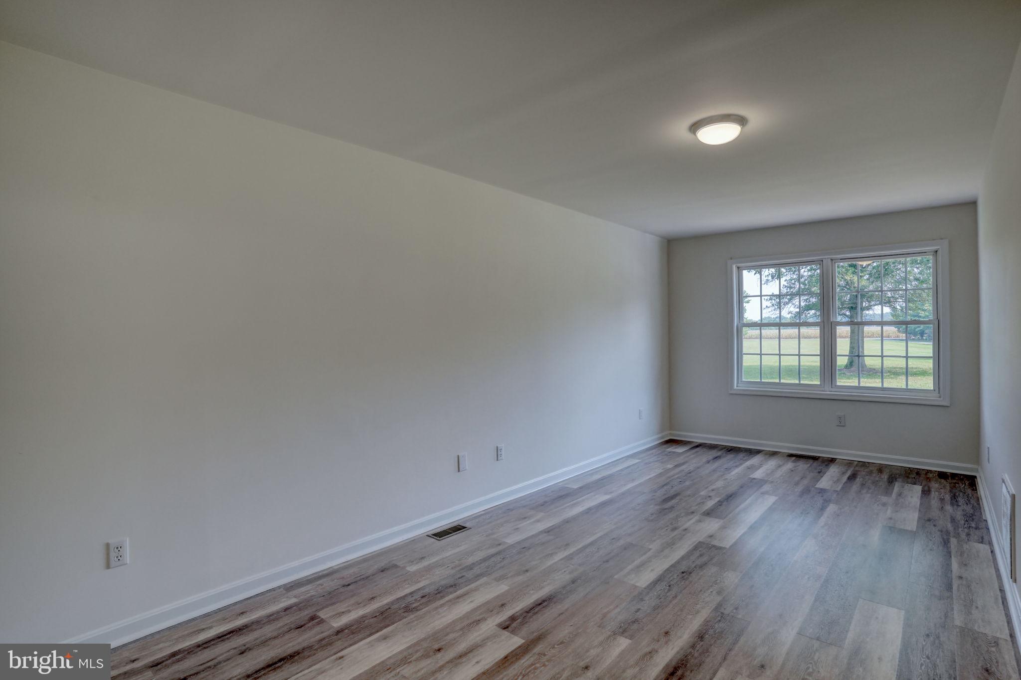 23678 Willow Pond Road Denton, MD 21629 - Photo 23 of 51 an empty room with wooden floor and windows