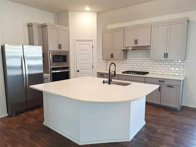 a kitchen with stainless steel appliances a sink and a refrigerator