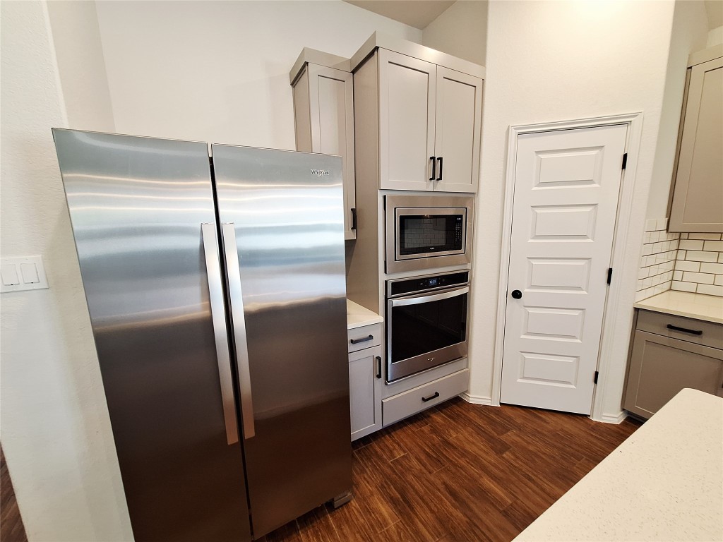 1104 River Vista Road Georgetown, TX 78628 - Photo 14 of 39 a kitchen with a refrigerator and white cabinets