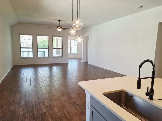 a view of a kitchen with a sink wooden floor and windows
