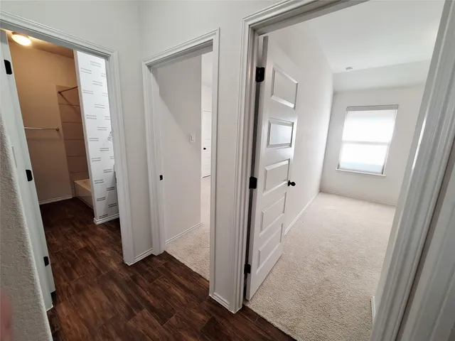 a view of a hallway with wooden floor and closet area