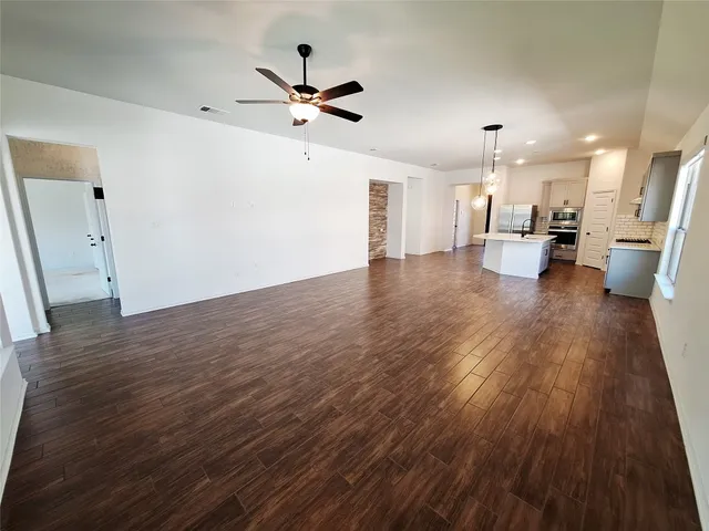 a view of a living room hardwood floor and a ceiling fan