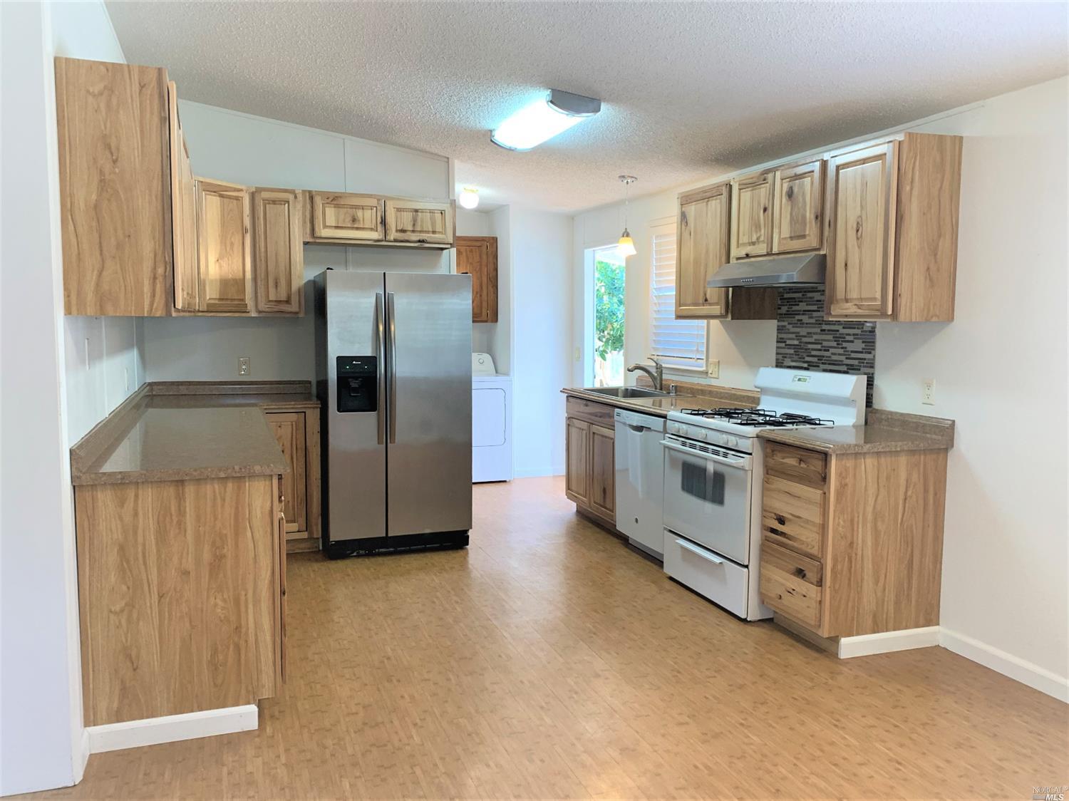a kitchen with stainless steel appliances a refrigerator a stove a sink and a cabinets