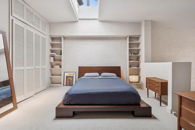 a bedroom with a bed and a flat tv screen