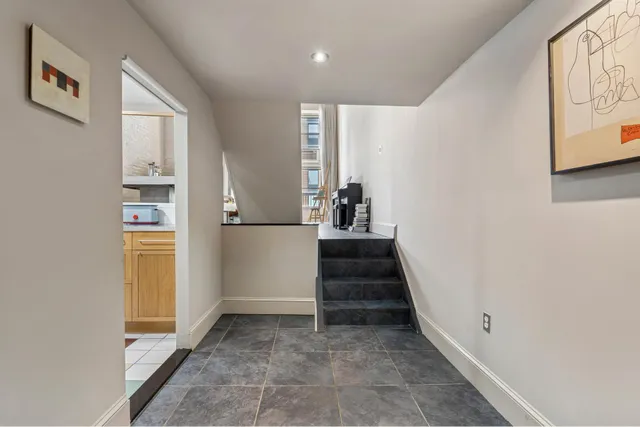 a view of a hallway with wooden floor and entryway