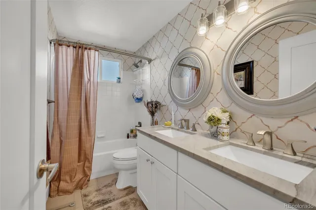 a bathroom with a granite countertop toilet a sink and mirror