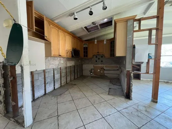 a kitchen with stainless steel appliances kitchen island granite countertop a refrigerator and a stove top oven