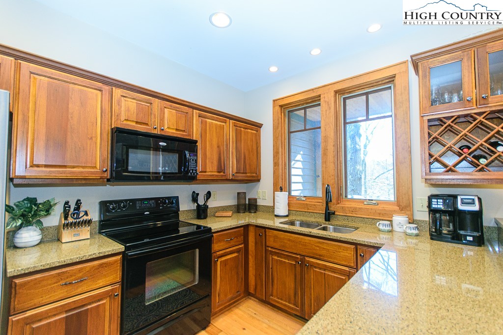 145 Rising Fawn Pass, Unit 17B Boone, NC 28607 - Photo 12 of 49 a kitchen with stainless steel appliances granite countertop a stove a sink and a microwave