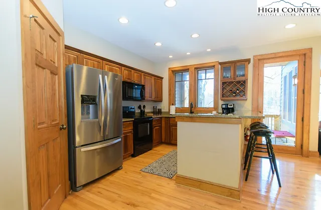 a kitchen with stainless steel appliances granite countertop a refrigerator a stove top oven a sink and dishwasher