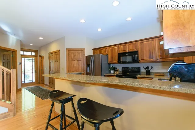 a large kitchen with stainless steel appliances granite countertop a sink and cabinets