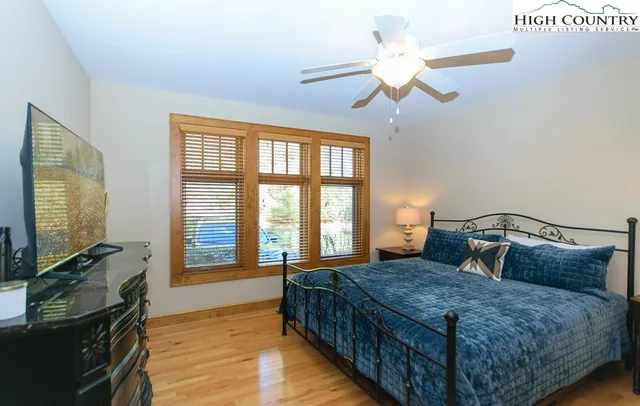 a bedroom with a large bed and a flat tv screen on dresser