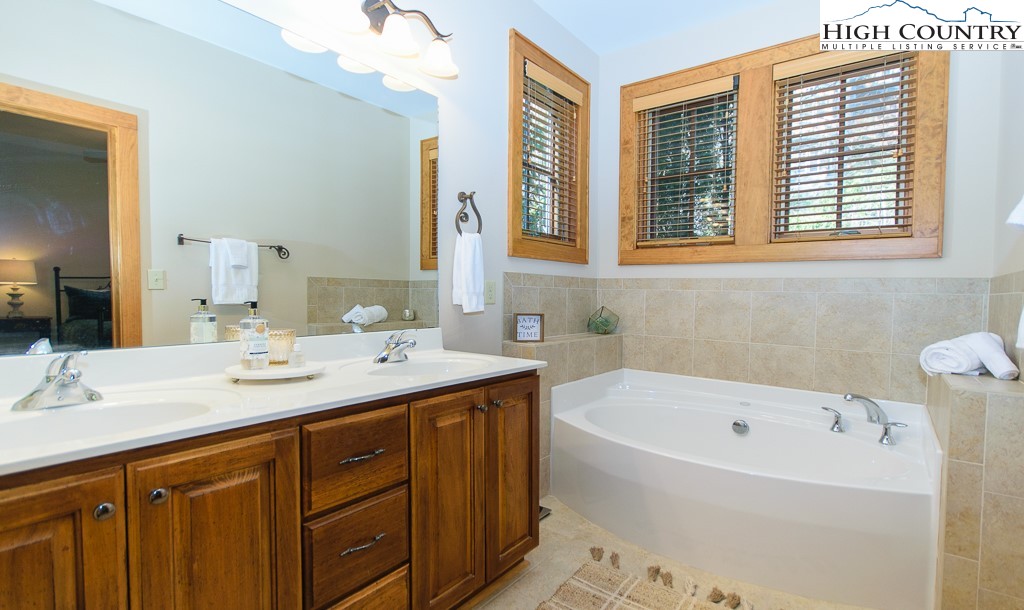 145 Rising Fawn Pass, Unit 17B Boone, NC 28607 - Photo 20 of 49 a bathroom with a tub sink and mirror