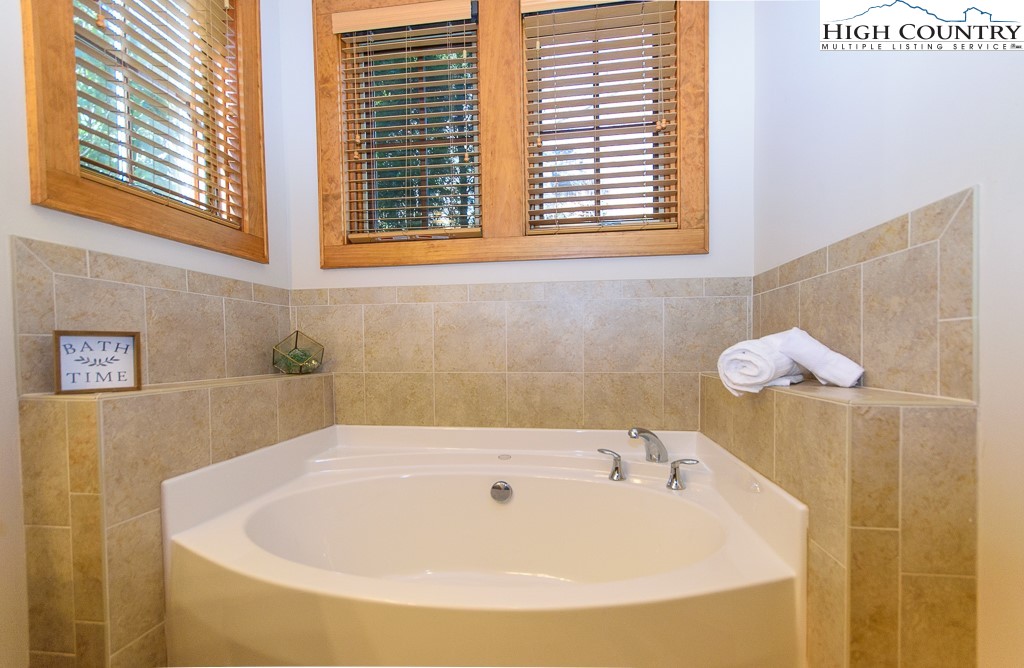 145 Rising Fawn Pass, Unit 17B Boone, NC 28607 - Photo 23 of 49 a bathroom with a tub and a window