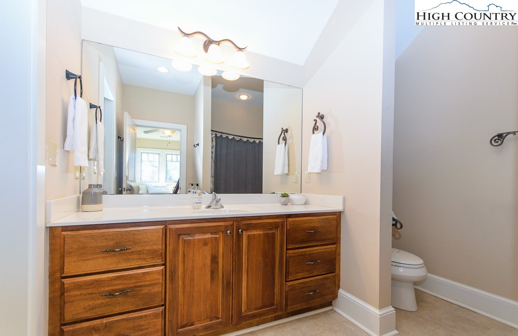 145 Rising Fawn Pass, Unit 17B Boone, NC 28607 - Photo 29 of 49 a bathroom with a granite countertop sink mirror vanity and toilet