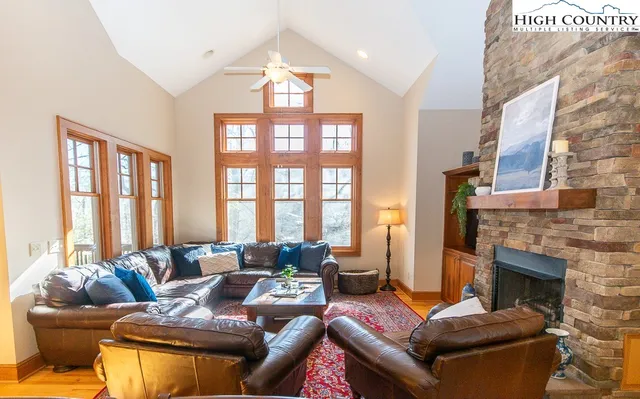 a living room with furniture fireplace and a large window