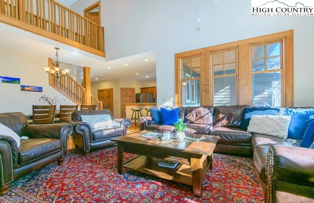 a living room with furniture a rug and a large window
